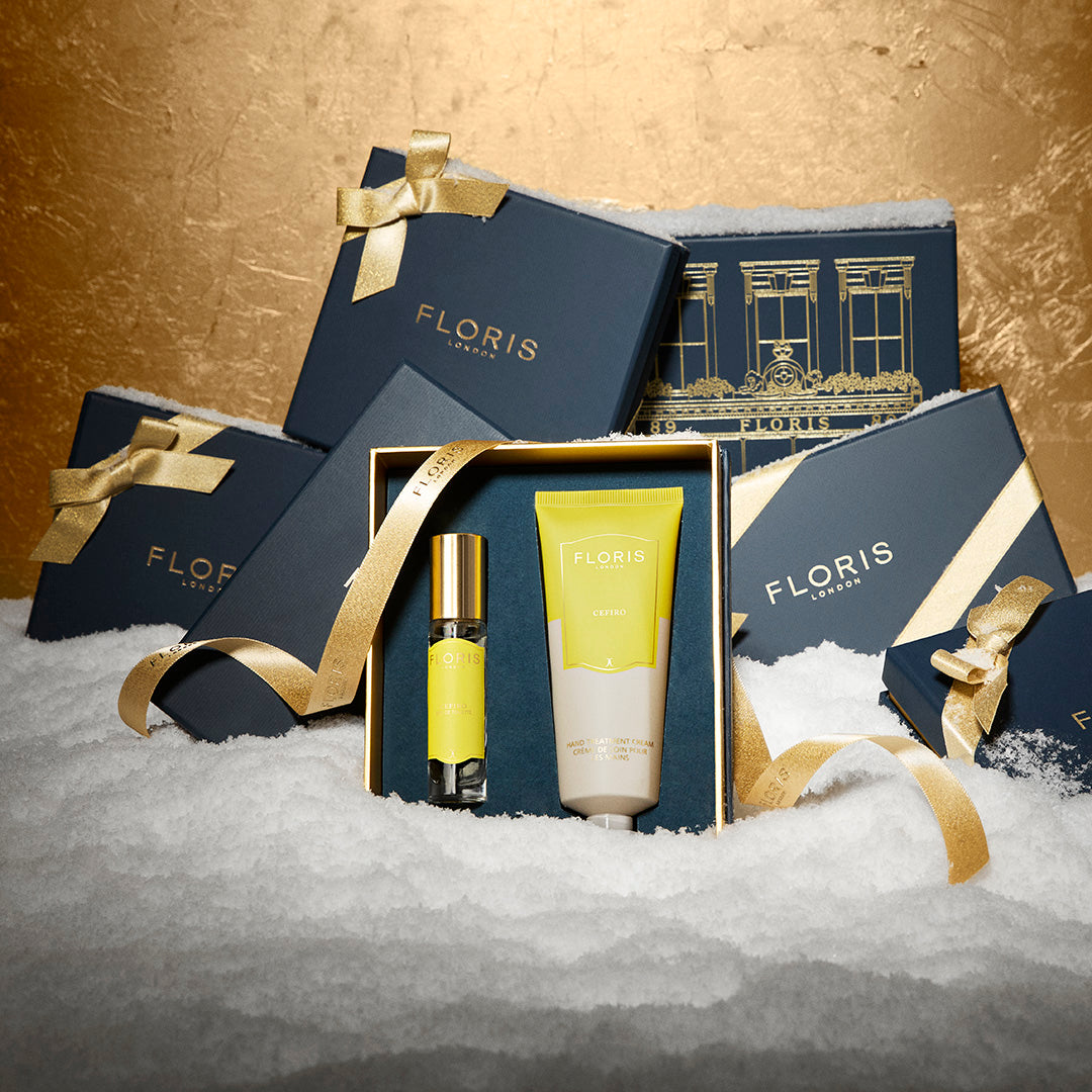 Floris London UK gift boxes with yellow ribbons rest on snow, showcasing the Cefiro Hero | Cefiro Duo set with Eau de Toilette and body lotion.