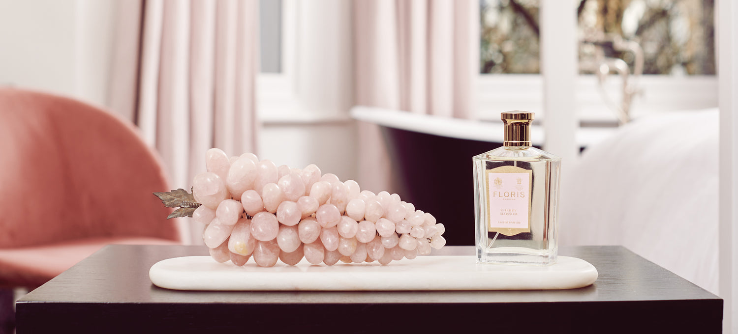 A Pink image with Pink grapes and a bottle of Cherry Blossom Eau de Parfum