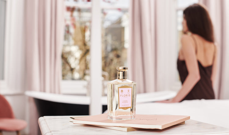 Blurred image of a lady in the background and a bottle of Floris London Cherry Blossom Eau de Parfum