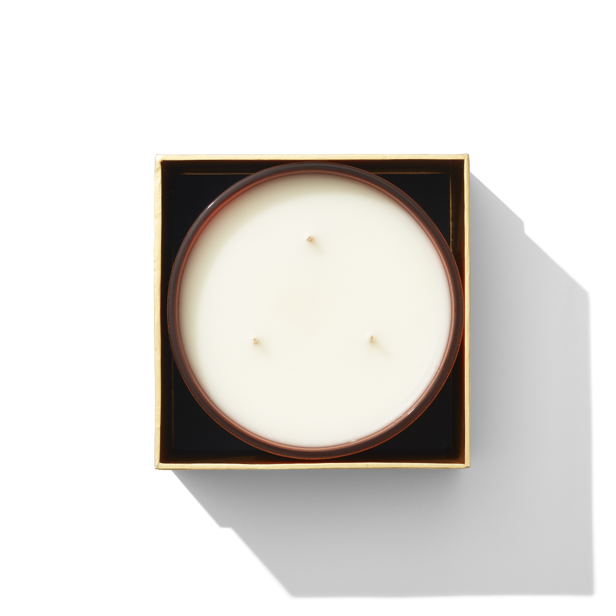 An open box with a candle inside, it has three wicks 