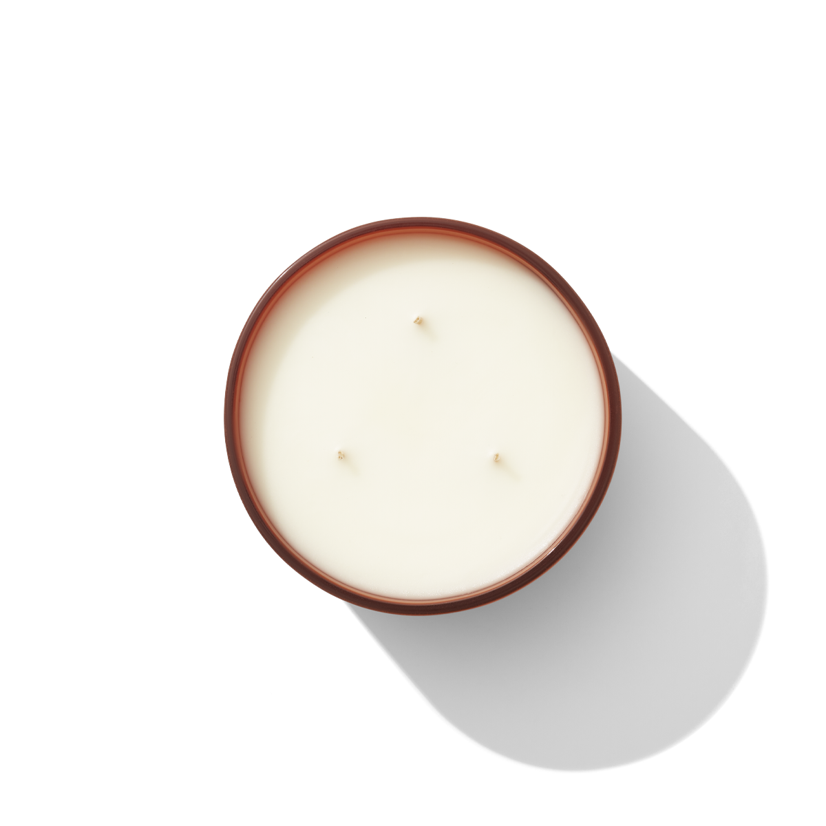 an aerial view of a three wick candle, it is white. 