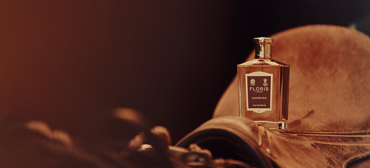 A brown background of a Leather saddle and Floris London Leather Oud Eau de Parfum