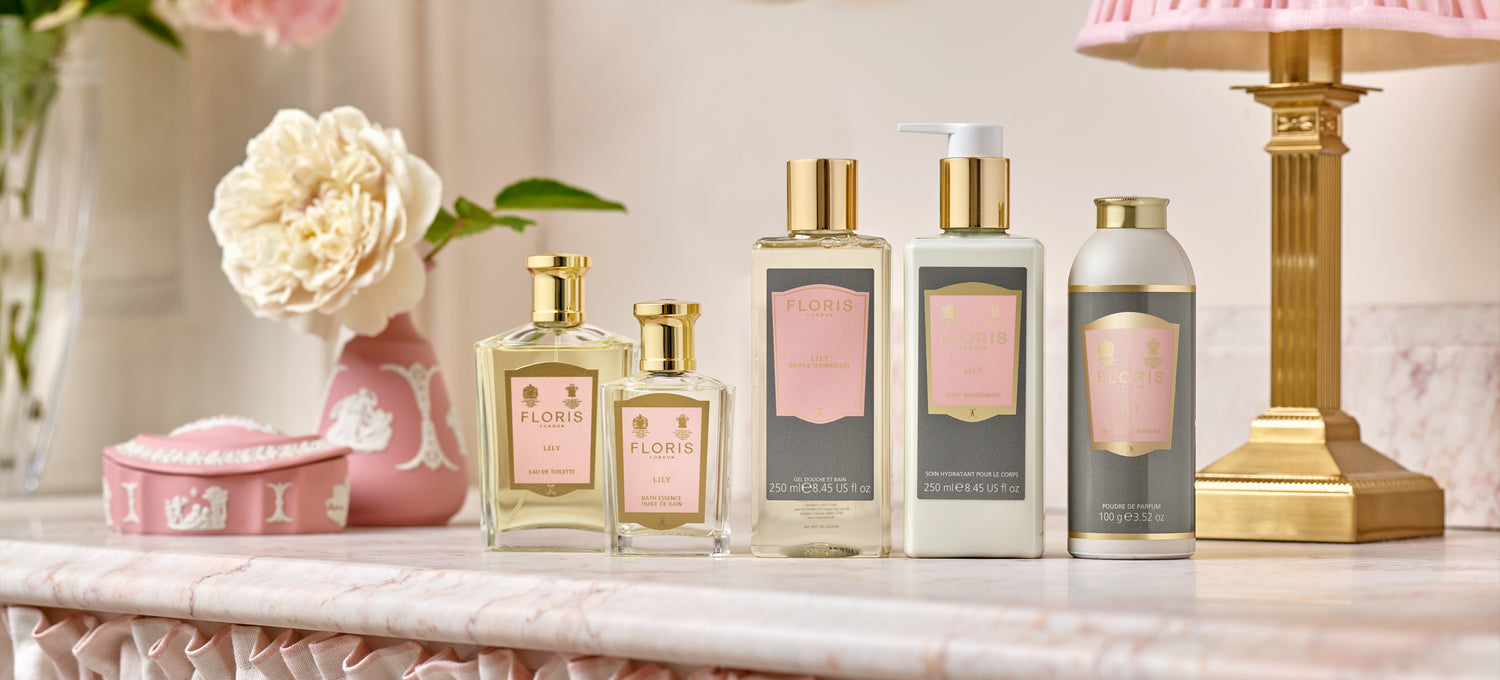 The Floris London Lily collection displayed on a pink marble table in a stylish powder room.