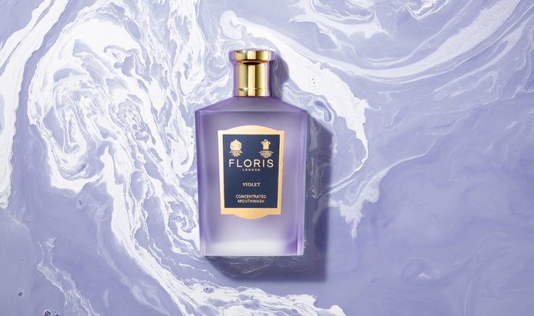 Close up image of floris london Violet Mouthwash on a Purple and White swirled background 