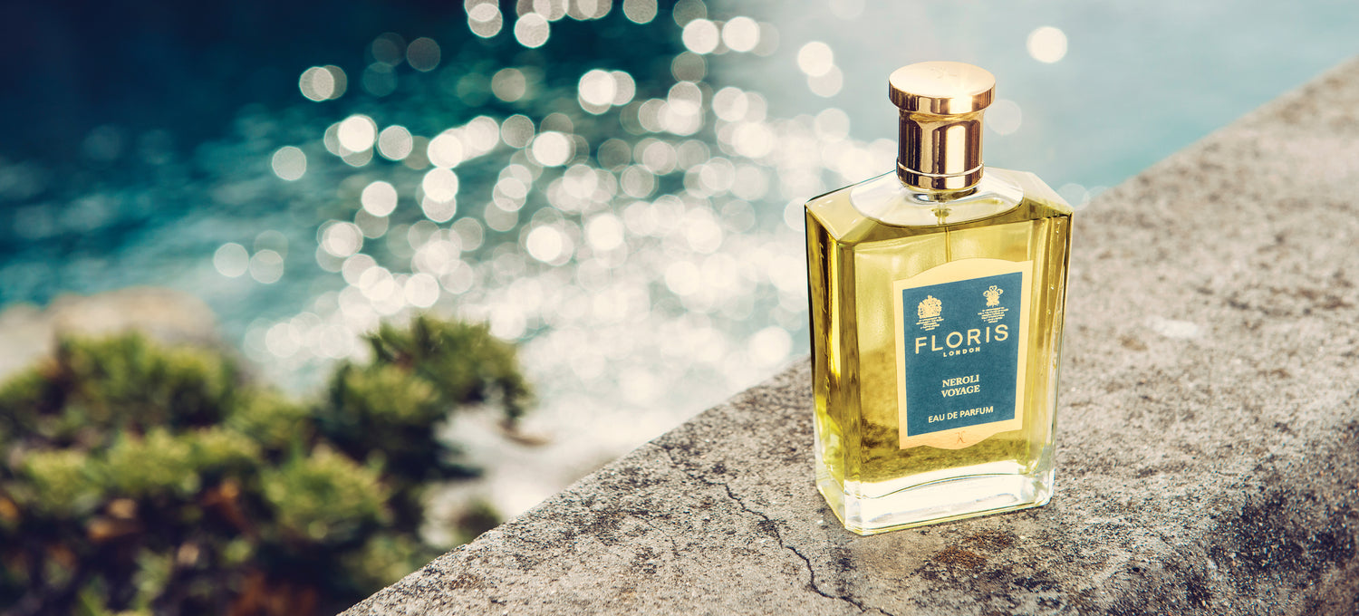 Bottle of Neroli Voyage on a stone wall with the ocean in the background