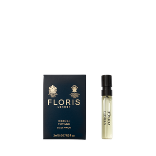 A perfume sample bottle sits next to a navy Floris London box labeled "Neroli Voyage - Eau de Parfum," exuding the scent of neroli and warm amber.