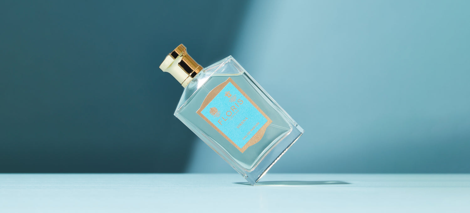 A bottle of Floris London Sirena Eau de Parfum on it's side on a Blue background 