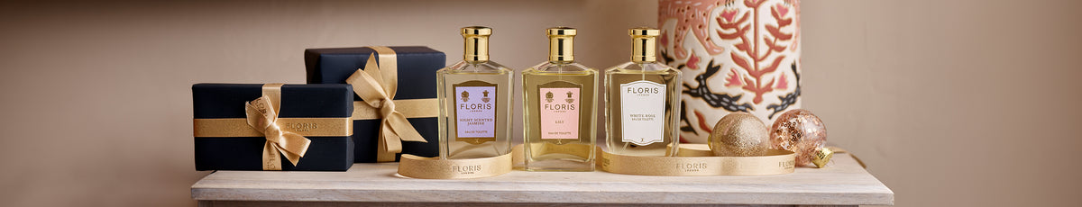 A collection of skincare products displayed on a wooden shelf next to open books.