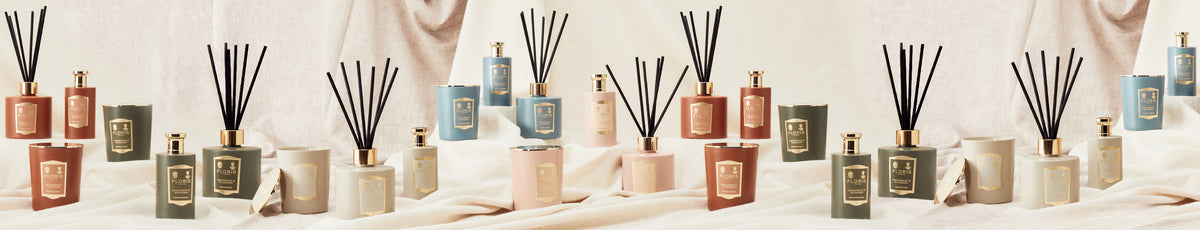 Aesthetic display of scented candles and reed diffusers on a soft fabric background.
