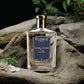 A Floris London 71/72 Eau de Parfum bottle rests on driftwood amid greenery and stones, evoking an air of refined woody fragrance.