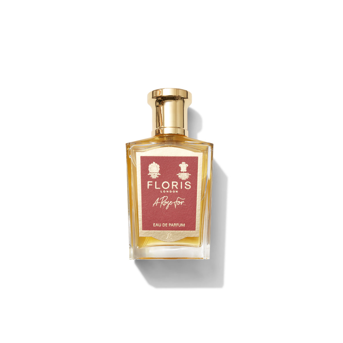 A bottle of Floris London A Rose For... Eau de Parfum, a signature scent with a gold cap and red label bearing the brand name and signature, stands elegantly against a white background. This 100ml bottle makes for a unique gift.