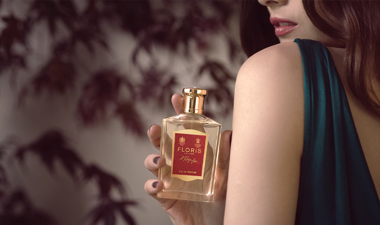 Lady holding a bottle of A Rose For... Eau de Parfum with a green dress on