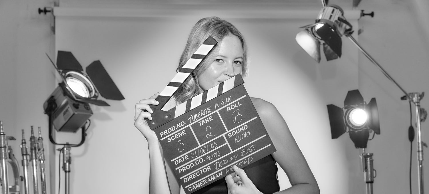 Model holding a clapperboard with lights in the background 