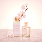 Two Floris London UK Cherry Blossom - Enriched Body Moisturiser bottles with gold caps beside pink cherry blossoms on a pink surface.