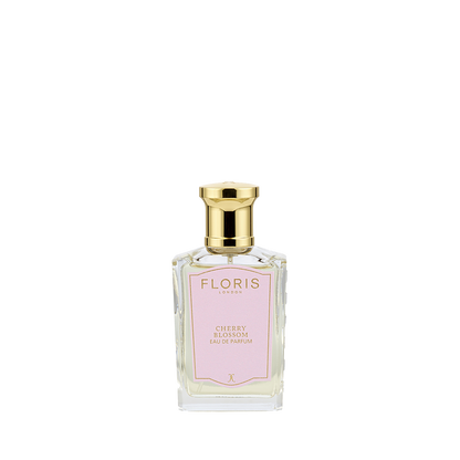A clear glass bottle of Floris London Cherry Blossom - Eau de Parfum, with a gold cap and pink label, delivers a delicate Sakura-inspired floral-fruity scent.