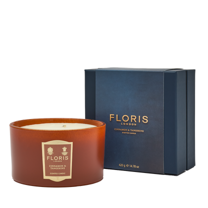 The Cinnamon & Tangerine Deluxe Three Wick Candle by Floris London, in a blue box, fills any space with a warm and inviting aroma.