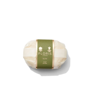 Bar of Elite Soap by Floris London, featuring a green and gold label, elegantly wrapped in paper against a white background. This luxurious soap offers a blend of woody notes with a subtle citrus twist.