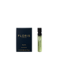 Small blue box and green vial labeled "Floris London Elite - Eau de Toilette 2 ml," offering a captivating woody fragrance.