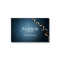 A Floris London UK Gift Card featuring a blue background and a gold ribbon along the right edge.