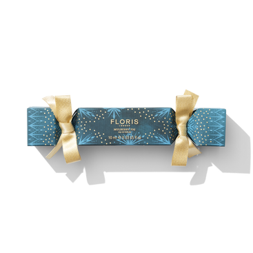 A blue festive cracker with gold ribbon tied around it