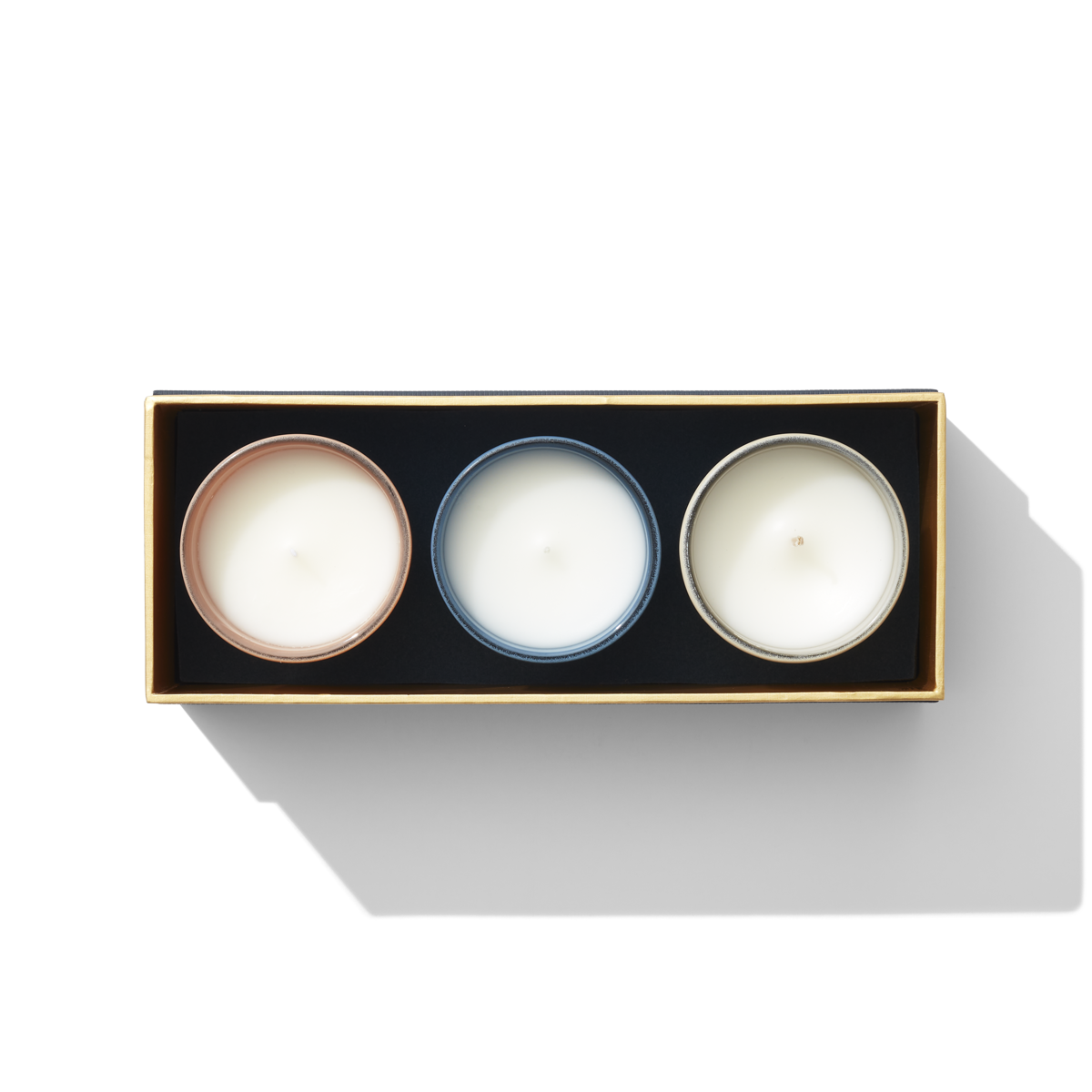 an aerial view of three small candles. they are different colours. 