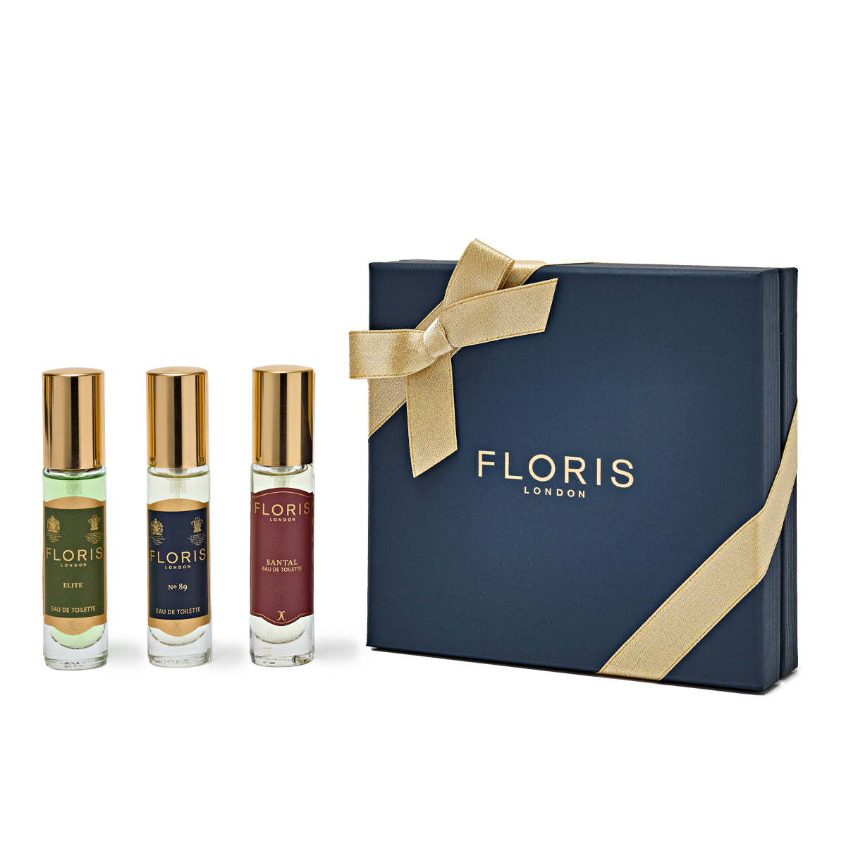 The Perfumer's Trilogy: For Him (2024 xmas) gift set by Floris London features three distinguished British fragrances, elegantly presented next to a navy box adorned with a gold ribbon.