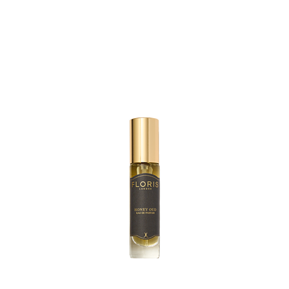 A bottle of Floris London's Honey Oud Eau de Parfum features a gold cap, dark label, and is enriched with notes of English honey and oud oil.