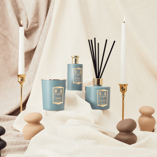 Floris London's Hyacinth & Bluebell reed diffuser exudes a green floral fragrance with hyacinth notes, perfect with candles and tall golden holders.