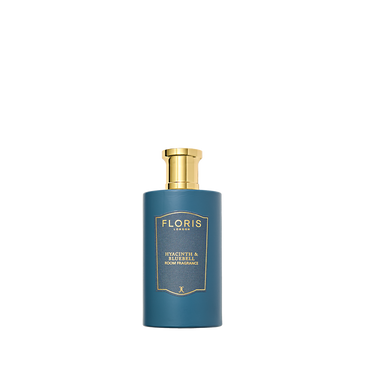 Blue cylindrical perfume bottle by Floris London, gold cap and label, "Hyacinth & Bluebell - Room Fragrance" text, exuding a green floral scent.