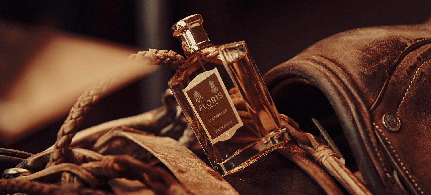 Brown leather saddle with a bottle of Floris Leather Oud Eau de Parfum on top