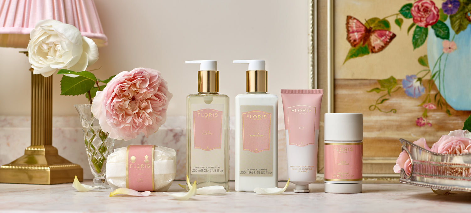 The Floris London Lily collection displayed on a pink marble table in a stylish powder room.