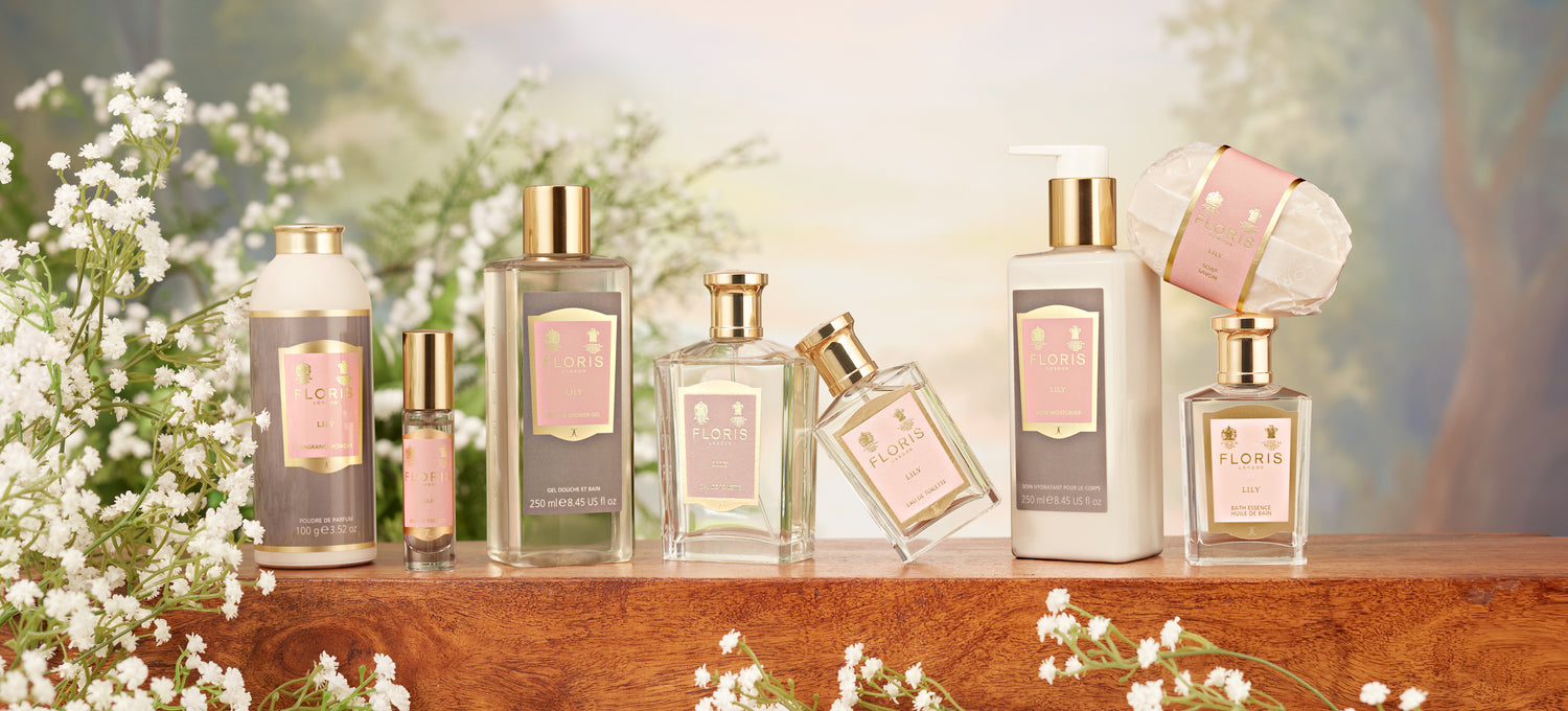A floral pink background with the Floris London Lily collection on a wooden table 