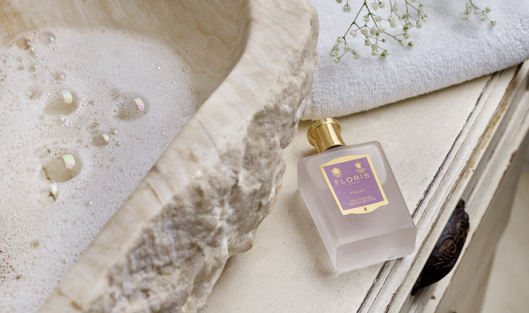 A bottle of Floris London Violet Mouthwash, place beside a sink filled with soapy water. 