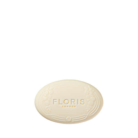 Floris London's Night Scented Jasmine Soap is oval-shaped with a floral design and text, providing creamy lather and shea butter's softness on a cream background.