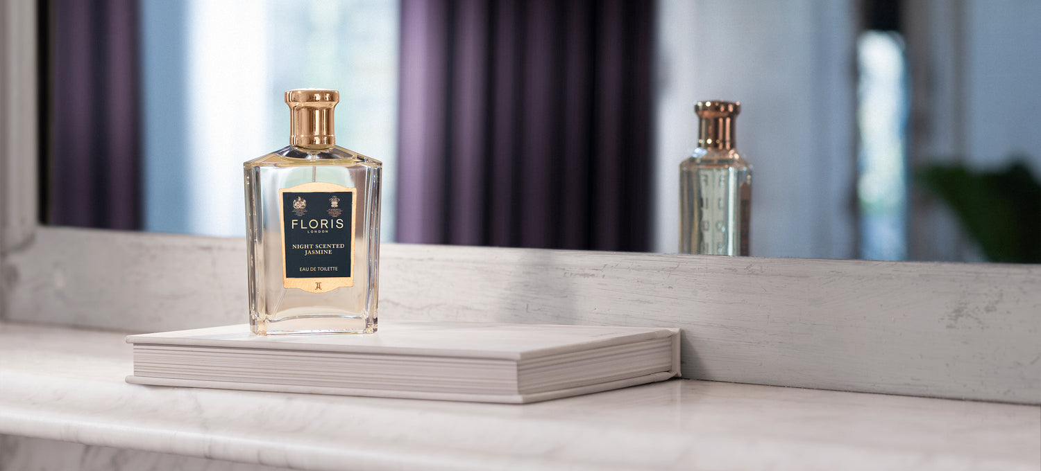 A bottle of Floris London White Scented Jasmine Eau de Toilette in a mirror 