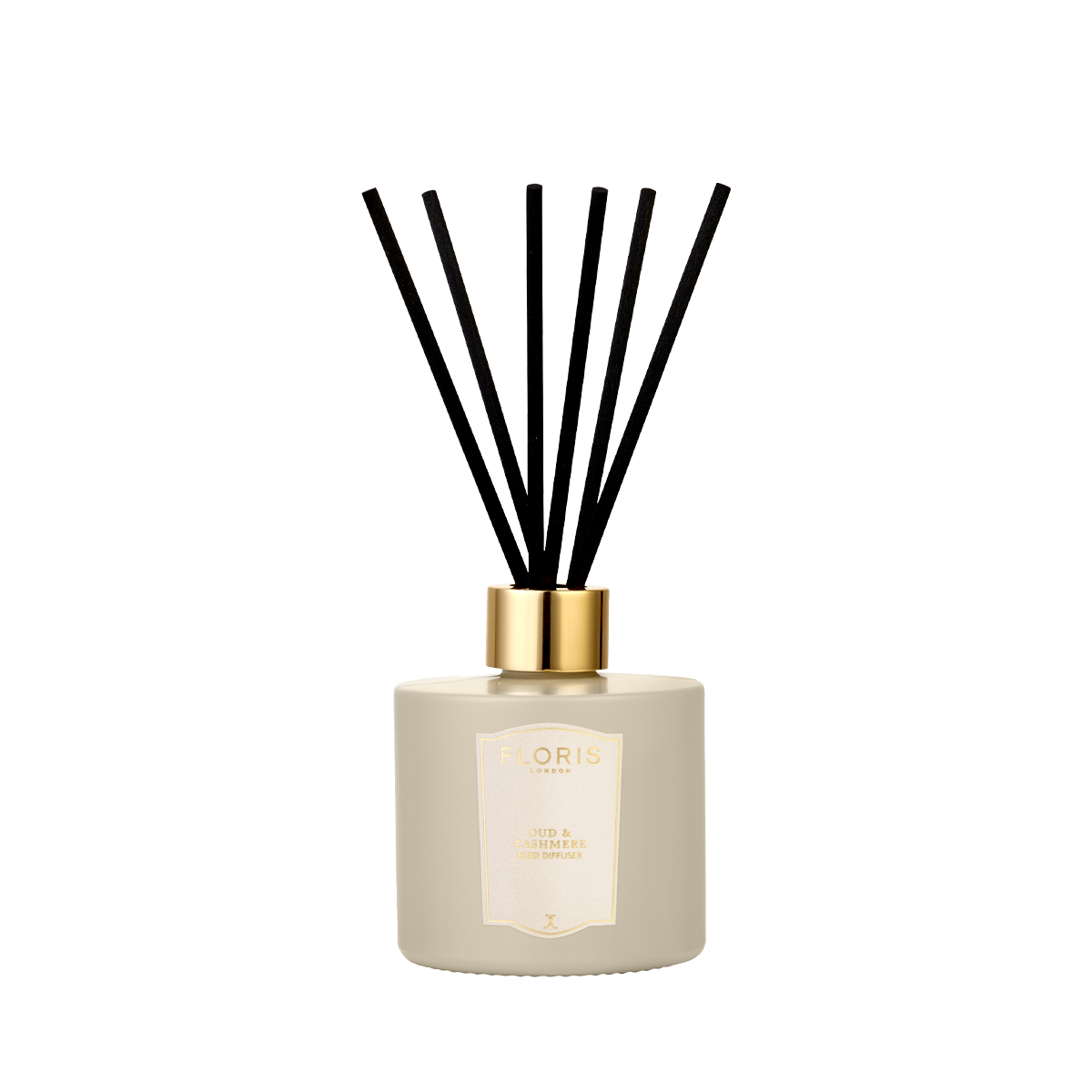 A Floris London Oud & Cashmere reed diffuser in beige with a gold cap and black reeds, shown on a plain white background.