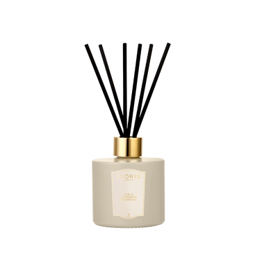 A Floris London Oud & Cashmere reed diffuser in beige with a gold cap and black reeds, shown on a plain white background.