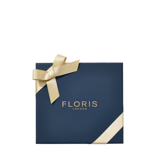Navy blue gift box with gold ribbon and "Floris London"—Perfumer’s Trilogy: For Him, an elegant festive gift inspired by British men’s fragrances.