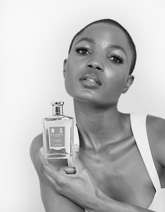 A model holding a bottle of Floris perfume close to her face