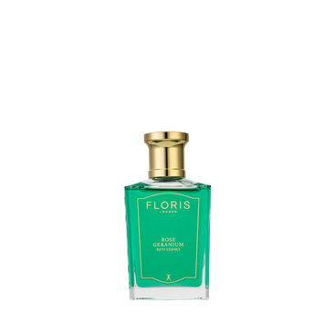 A green glass bottle of Floris London Rose Geranium - Bath Essence, rich in concentrated fragrance, rests on a simple white background.