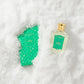 A Floris London UK Rose Geranium | Limited Edition perfume bottle and box partially buried in white snow.