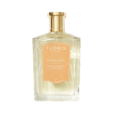 Clear perfume bottle labeled "Floris London UK, Sandalwood," featuring sandalwood oil with a gold cap and light brown label.