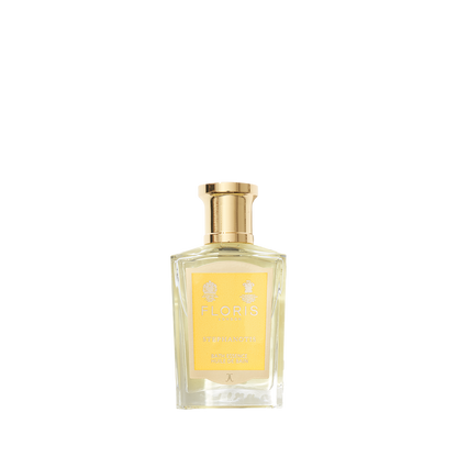 Clear glass bottle with gold cap containing Floris London Stephanotis - Bath Essence, featuring a floral fragrance and a yellow label.