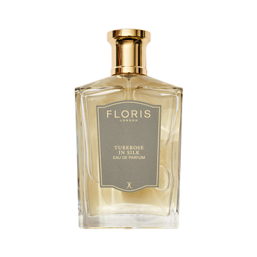A clear glass bottle of Floris London Tuberose in Silk - Eau de Parfum, a luxurious fragrance with a gold cap and gray label.