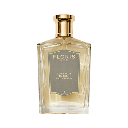 A clear glass bottle of Floris London Tuberose in Silk - Eau de Parfum, a luxurious fragrance with a gold cap and gray label.