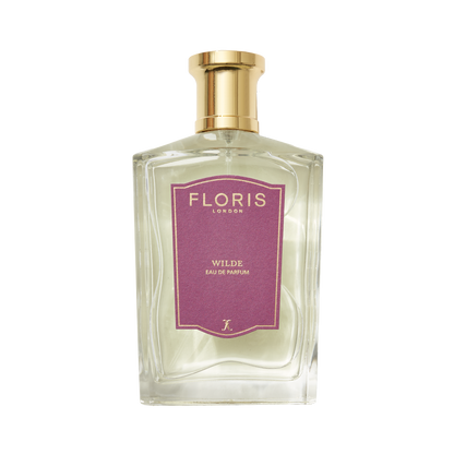 Clear glass bottle of Floris London's Wilde Eau de Parfum, inspired by Oscar Wilde, with a gold cap and purple label celebrating individuality.