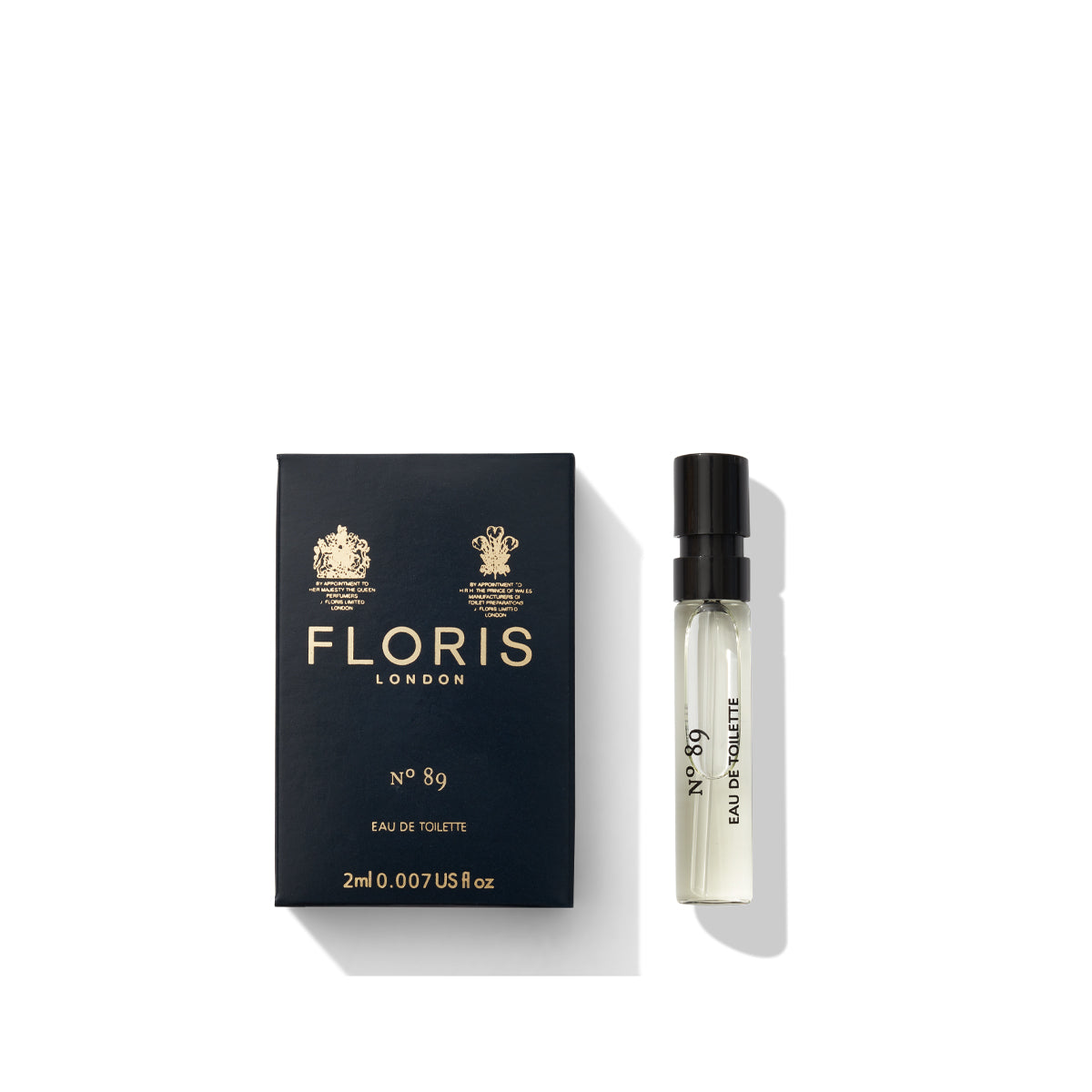 A black box with the text "Floris London No. 89 - Eau de Toilette" sits beside a small, clear perfume vial with a black cap, embodying a classic cologne that captures the essence of an English gentleman's fragrance.